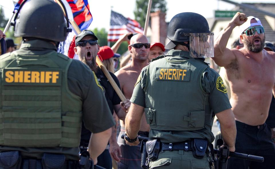 Orange County Sheriff deputies keep protesters and counter protesters apart in Yorba Linda, Calif., Saturday, Sept. 26, 2020. Police eventually declared the event an unlawful gathering and cleared the streets near Yorba Linda and Imperial. Authorities said people were struck by a car and injured during the Black Lives Matter protest and counter protest about 30 miles southeast of Los Angeles. Orange County Sheriff's Department spokeswoman Carrie Braun says the injured were transported to a hospital with non-life-threatening injuries and the driver was detained. (Mindy Schauer/The Orange County Register via AP)