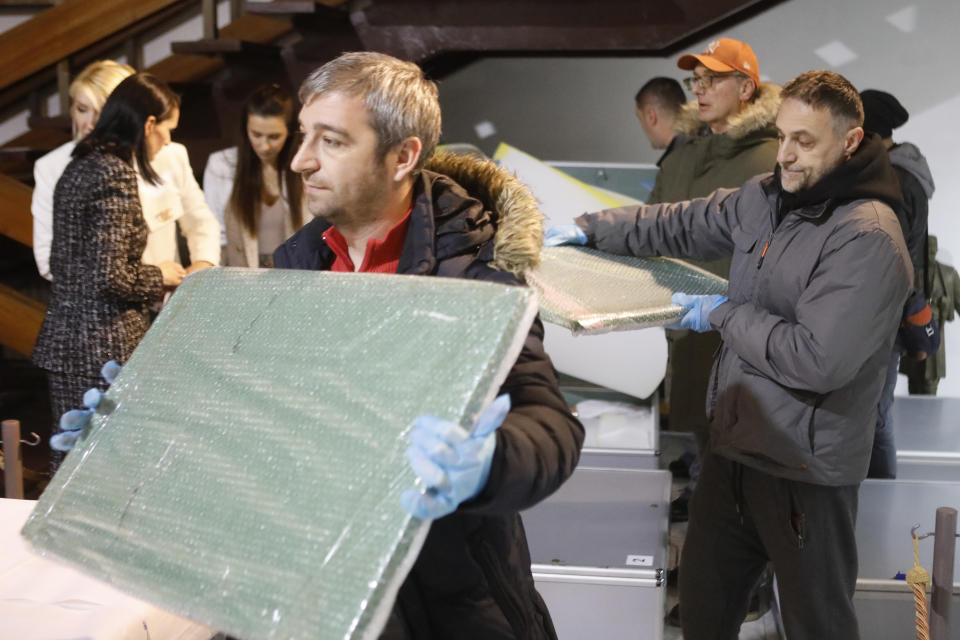 Museum workers unpack the icons returned from Albania upon the arrival at the National museum in Skopje, North Macedonia, late Friday, Dec. 15, 2023. Albania on Friday returned 20 icons to neighboring North Macedonia that were stolen a decade ago. (AP Photo/Boris Grdanoski)