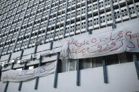 Banners are hung on a building in Tunis' landmark Avenue Habib Bourgiba, where massive protests took place in 2011, on the tenth anniversary of the uprising , in Tunis, Thursday, Jan. 14, 2021. Banners read "The uprising of the poor begins" Tunisia is commemorating the 10th anniversary since the flight into exile of its iron-fisted leader, Zine El Abidine Ben Ali, pushed from power in a popular revolt that foreshadowed the so-called Arab Spring. But there will be no festive celebrations Thursday marking the revolution in this North African nation, ordered into lockdown to contain the coronavirus. (AP Photo/Mosa'ab Elshamy)