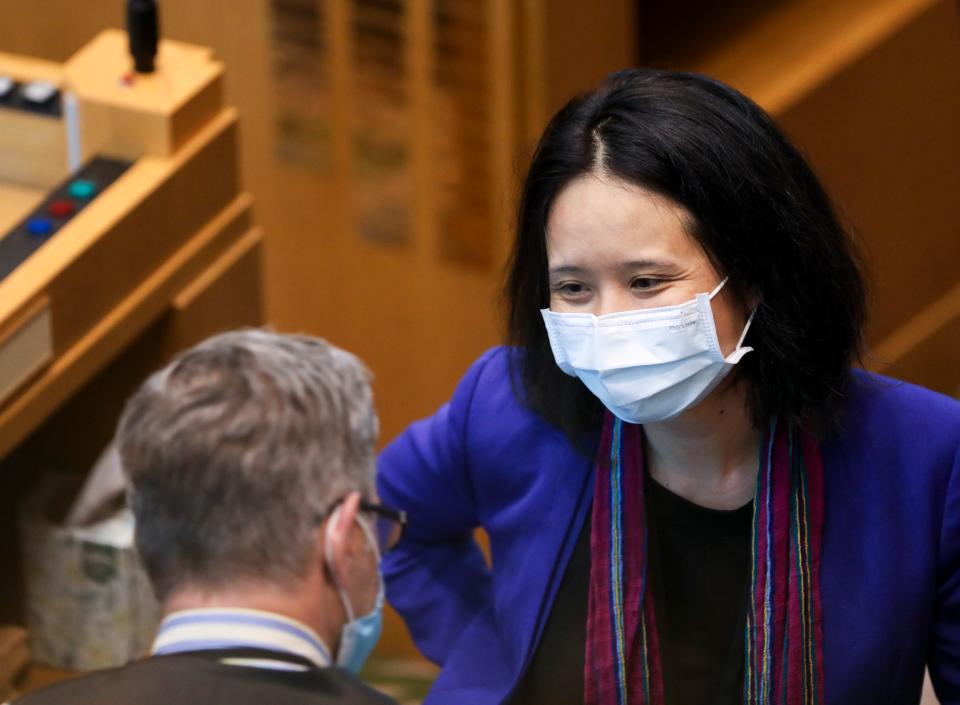 Rep. Khanh Pham talks with a fellow lawmaker during the legislative session in June.