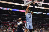 Memphis Grizzlies forward David Roddy, right, shoots the ball past Los Angeles Clippers forward Paul George during the second half of an NBA basketball game, Sunday, Nov. 12, 2023, in Los Angeles. (AP Photo/Ryan Sun)