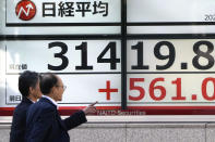 People walk past an electronic stock board showing Japan's Nikkei 225 index at a securities firm Wednesday, Nov.1, 2023 in Tokyo. Asian shares were mostly higher Wednesday after Wall Street advanced to claim back some of the ground it gave up in another losing month. (AP Photo/Shuji Kajiyama)