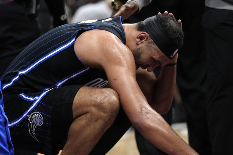 Orlando Magic's Jalen Suggs is helped up after an injury during the second half of the team's NBA basketball game against the Cleveland Cavaliers, Thursday, Feb. 22, 2024, in Cleveland. (AP Photo/Sue Ogrocki)