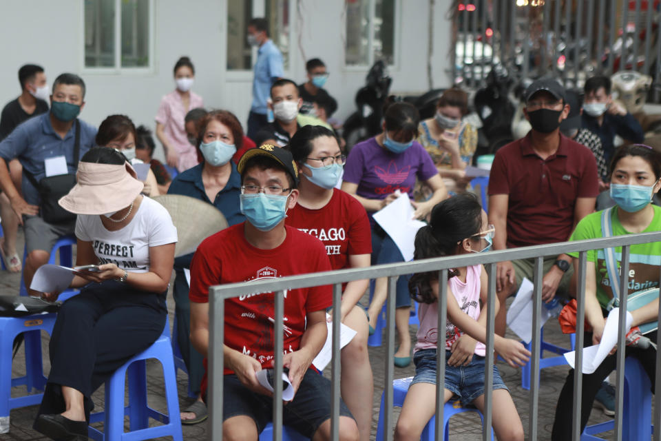 Varias personas aguardan el viernes 31 de julio de 2020 a que les hagan la prueba de COVID-19, en Hanoi, Vietnam. (AP Foto/Hau Dinh)