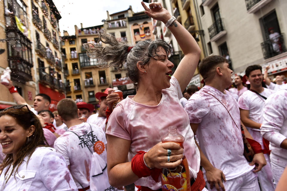 Revelers celebrate while waiting for the launch of the 'Chupinazo' rocket, to mark the official opening of the 2022 San Fermin fiestas in Pamplona, Spain, Wednesday, July 6, 2022. The blast of a traditional firework opens Wednesday nine days of uninterrupted partying in Pamplona's famed running-of-the-bulls festival which was suspended for the past two years because of the coronavirus pandemic. (AP Photo/Alvaro Barrientos)