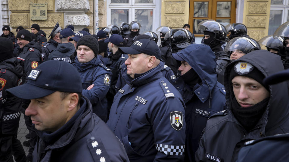 Police officers stand in line in front of protesters during a protest initiated by the Movement for the People and members of Moldova's Russia-friendly Shor Party, against the pro-Western government and low living standards, in Chisinau, Moldova, Tuesday, Feb. 28, 2023. Thousands of protesters returned to Moldova's capital Tuesday to demand that the country'snew pro-Western governmentfully subsidize citizens' winter energy bills amid skyrocketing inflation. (AP Photo/Aurel Obreja)