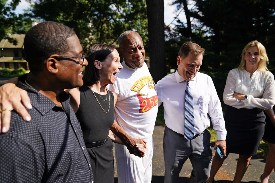 Image: Bill Cosby, center, listens to members of his team speaks with members of the media outside Cosby's home in Elkins Park, Pa., on June 30, 2021, after Pennsylvania's highest court overturned his sex assault conviction. (Matt Rourke / AP)