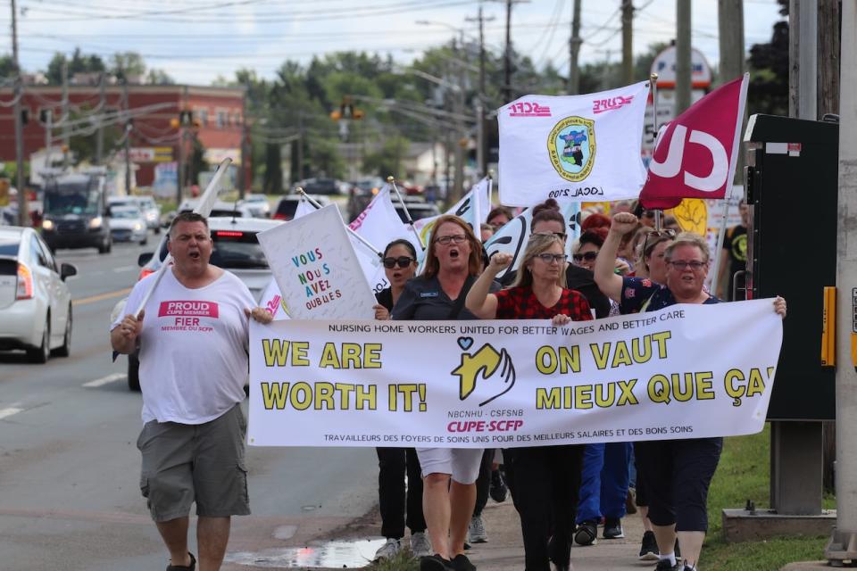 Nursing home workers walk along Mountain Road in Moncton's north end on Aug. 14, 2023. 