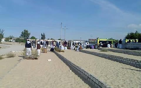 Egyptians gather outside the Rawda mosque, roughly 40 kilometres west of the North Sinai capital of El-Arish - Credit: AFP