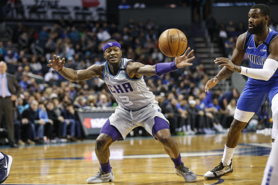 Charlotte Hornets guard Terry Rozier, left, beats Dallas Mavericks guard Tim Hardaway Jr. to a loose ball during the first half of an NBA basketball game in Charlotte, N.C., Saturday, Feb. 8, 2020. (AP Photo/Nell Redmond)