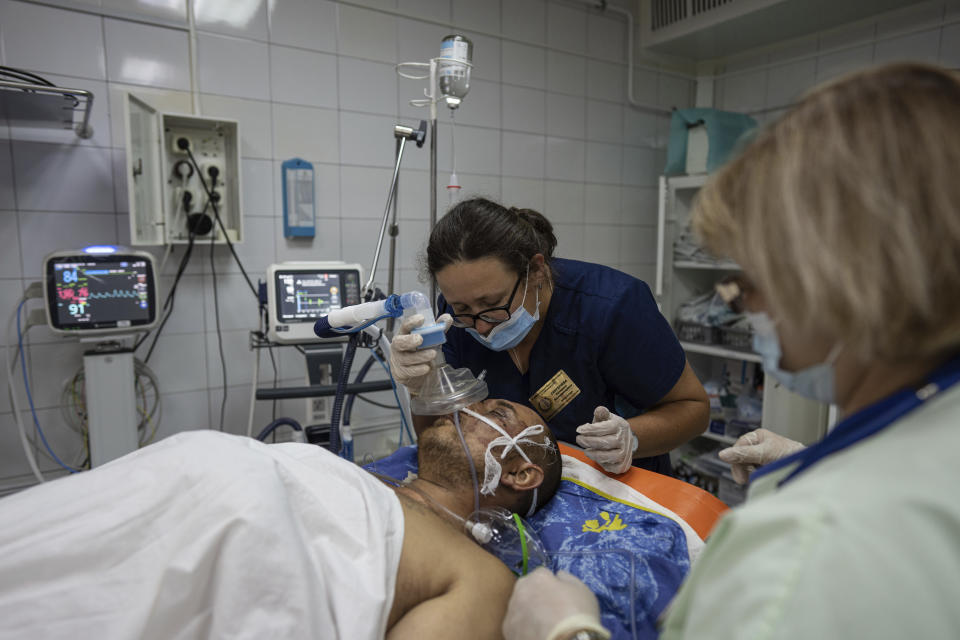 A doctor speaks to a wounded Ukrainian serviceman at the ICU department of Mechnikov Hospital in Dnipro, Ukraine, Friday, July 14, 2023. A surge of wounded soldiers has coincided with the major counteroffensive Ukraine launched last month to try to recapture its land from Russian forces. Surgeons at Mechnikov Hospital, one of the country's biggest, are busier now than perhaps at any other time since Russia began its invasion 17 months ago. (AP Photo/Evgeniy Maloletka)
