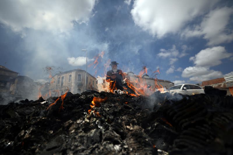 An Ultra-Orthodox Jewish man burns leaven in the Mea Shearim neighbourhood of Jerusalem ahead of the Jewish holiday of Passover amid coronavirus disease (COVID-19) restrictions