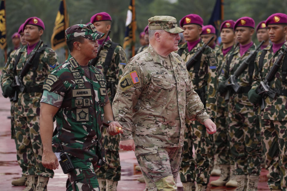 U.S. Chairman of the Joint Chiefs of Staff Gen. Mark Milley, center, and Indonesian Armed Forces Chief Gen. Andika Perkasa, left, inspect honor guards during their meeting at Indonesian military headquarters in Jakarta, Indonesia, Sunday, July 24, 2022. (AP Photo/Achmad Ibrahim)