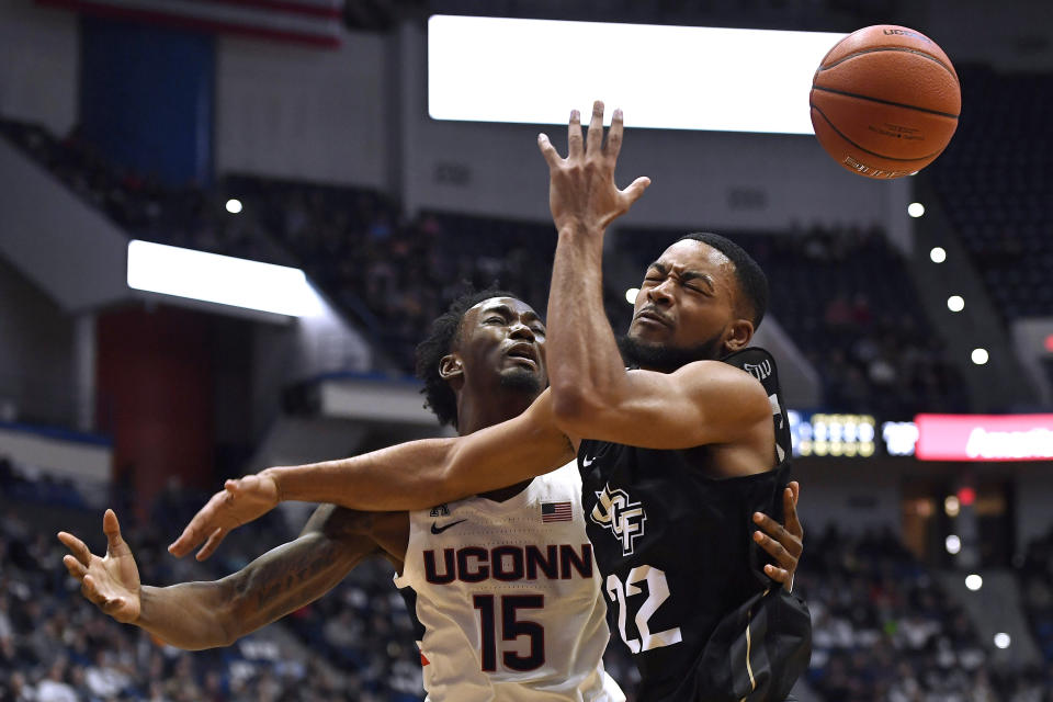 Connecticut's Sidney Wilson (15) loses the ball as he tangles with Central Florida's Darin Green Jr.(22) in the first half of an NCAA college basketball game, Wednesday, Feb. 26, 2020, in Hartford, Conn. (AP Photo/Jessica Hill)