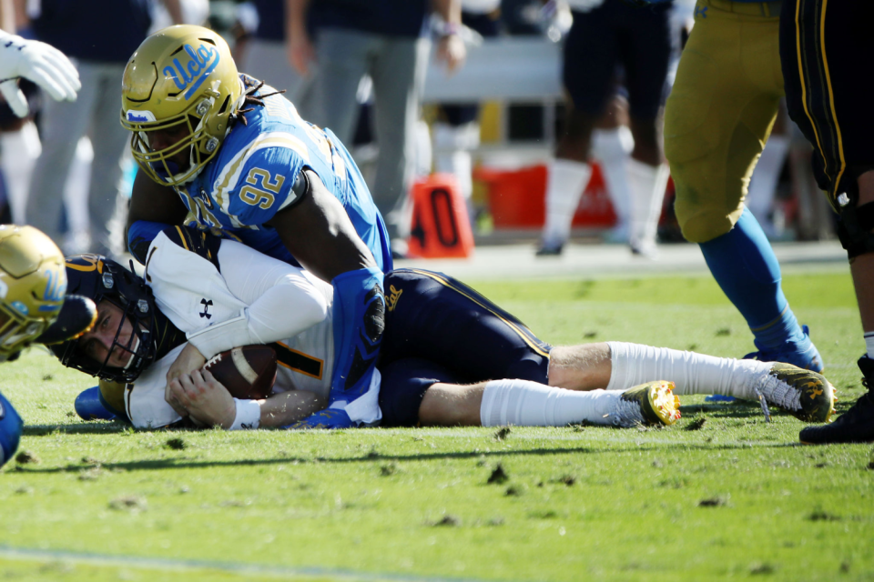 UCLA's Osa Odighizuwa brings down Cal's Chase Garbers on Nov. 15, 2020.