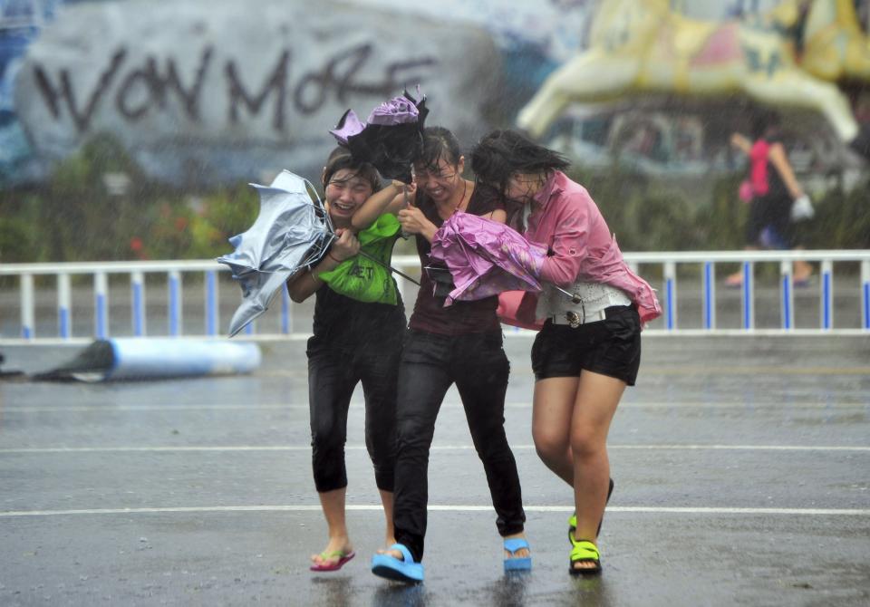 People cross a street against strong wind and heavy rainfall under the influence of Typhoon Haiyan, in Sanya, Hainan province November 10, 2013.