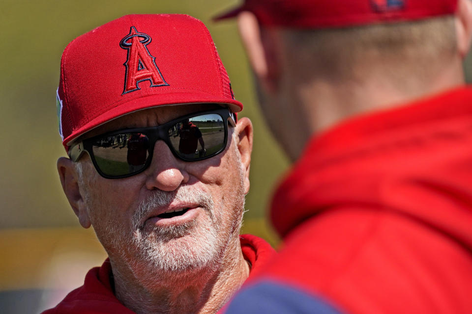 Los Angeles Angels manager Joe Maddon speaks with Mike Trout during the teams' spring training baseball workouts, Monday, March 14, 2022, in Tempe, Ariz. (AP Photo/Matt York)