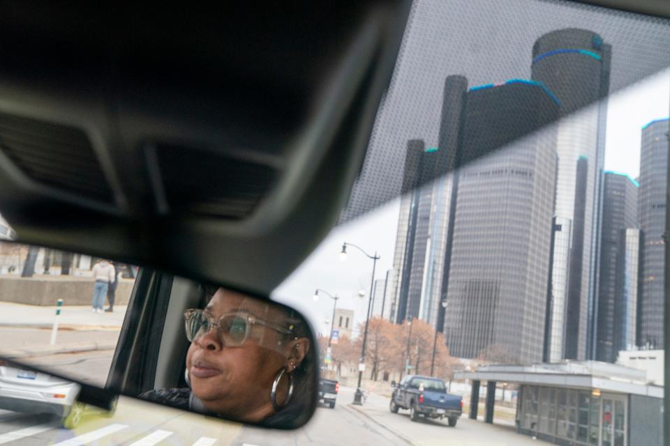 Charquiathia Rogers, 50, of Detroit, an outreach team member for Covenant House Michigan is reflected in the van's rearview mirror as she drives to take two people to a warming shelter in Detroit on Dec. 9, 2022.