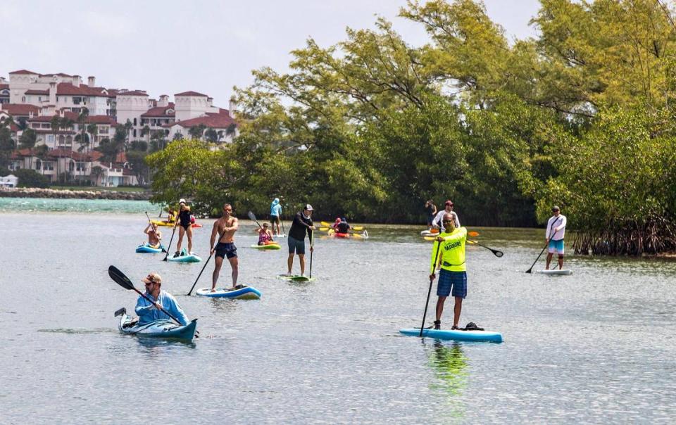 Un grupo de entusiastas de las actividades al aire libre, incluido el comisionado saliente de la Ciudad de Miami, Ken Russell (en el centro, de negro), se lanzaron al agua en tablas de paddle surf y kayaks en la laguna del Virginia Key Outdoor Center para protestar contra una propuesta de construir pequeñas casas en el cayo para personas sin hogar.