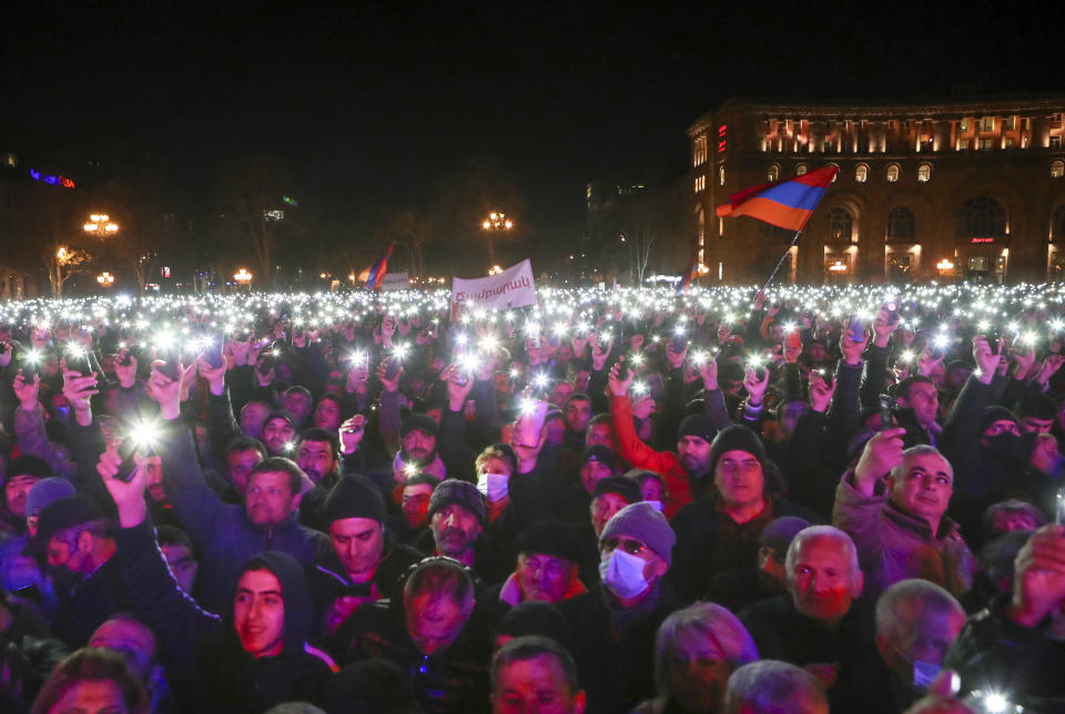 Supporters of Armenian Prime Minister Nikol Pashinyan hold up phones during a rally in the center of Yerevan, Armenia, Monday, March 1, 2021. Amid escalating political tensions in Armenia, supporters of the country's embattled prime minister and the opposition are staging massive rival rallies in the capital of Yerevan. Prime Minister Nikol Pashinyan has faced opposition demands to resign since he signed a peace deal in November that ended six weeks of intense fighting with Azerbaijan over the Nagorno-Karabakh region. (Hayk Baghdasaryan/PHOTOLURE via AP)