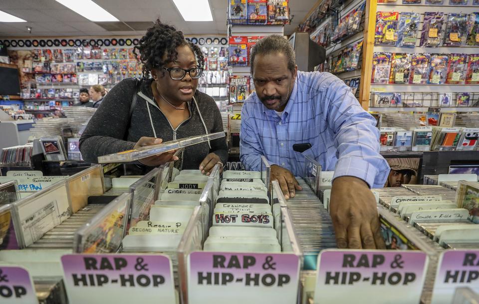 Ben Jones, right, owner of Better Days West, looks through CDs with customer Aiesha Cole. Nov. 7, 2018