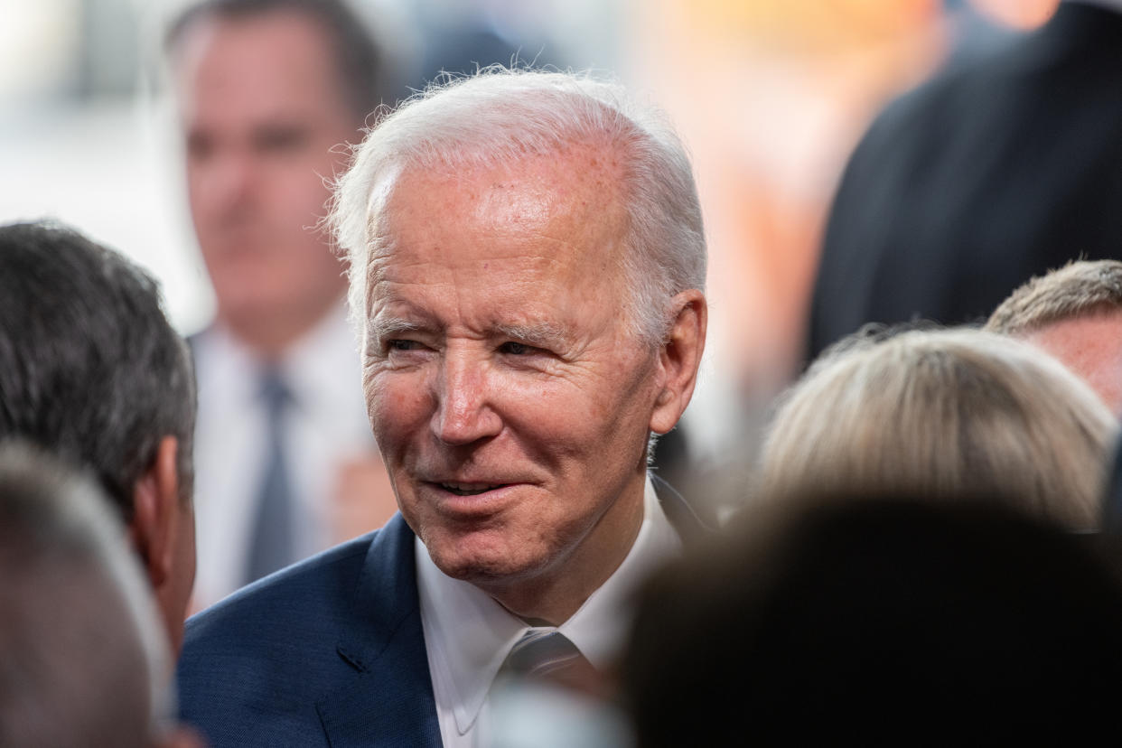 President Biden greets attendees during a ceremony at a semiconductor facility under construction.