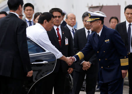 Philippine President Rodrigo Duterte (2nd L) is welcomed by a Japan Coast Guard (JCG) official as he visits for an inspection at the JCG base in Yokohama, south of Tokyo, Japan October 27, 2016. REUTERS/Issei Kato