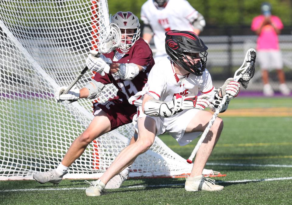 Rye's Caden Whaling (9) tries to duck away from Garden City's Ryan McKenna (23) during the boys lacrosse Class B state semifinal at University of Albany June 8, 2022.  Garden City won the game 6-4.