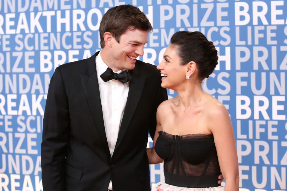 Ashton Kutcher and Mila Kunis look in love on the red carpet. (Photo: Getty Images)