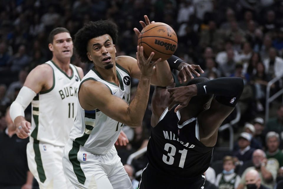 Milwaukee Bucks' Jordan Nwora (13) steals the ball from Brooklyn Nets' Paul Millsap (31) during the first half of an NBA basketball game Tuesday, Oct. 19, 2021, in Milwaukee. (AP Photo/Morry Gash)