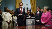 Virginia Gov. Glenn Youngkin, second from left, addresses the media as he prepares to sign executive orders in the Governors conference room as Lt. Gov. Winsome Earle-Sears, left, Attorney General Jason Miyares, second from right, and Secretary of the Commonwealth, Kay Cole James, right, look on at the Capitol Saturday Jan. 15, 2022, in Richmond, Va. (AP Photo/Steve Helber)