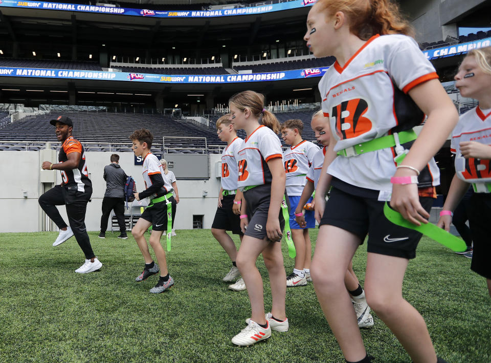 Player Giovani Bernard of the Cincinnati Bengals coaches a young team during the final tournament for the UK's NFL Flag Championship, featuring qualifying teams from around the country, at the Tottenham Hotspur Stadium in London, Wednesday, July 3, 2019. The new stadium will host its first two NFL London Games later this year when the Chicago Bears face the Oakland Raiders and the Carolina Panthers take on the Tampa Bay Buccaneers. (AP Photo/Frank Augstein)