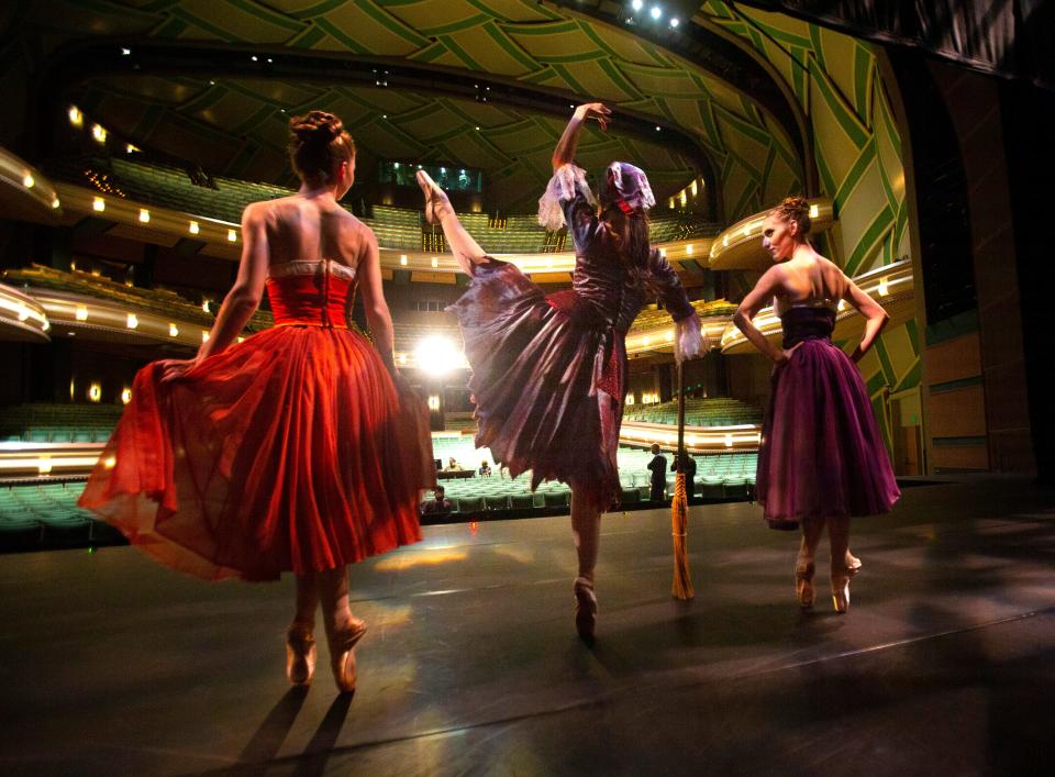 Eugene Ballet dancers Sarah Kosterman, left, as a stepsister; Danielle Tolmie, as Cinderellla; and Hayley Tavonatti as the other stepsister warm up on stage at The Hult Center after a two-year absence due to the pandemic.