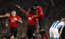 Manchester United's Paul Pogba, center, celebrates scoring against Huddersfield during the English Premier League soccer match at Old Trafford, Manchester, England, Wednesday Dec. 26, 2018. (Martin Rickett/PA via AP)