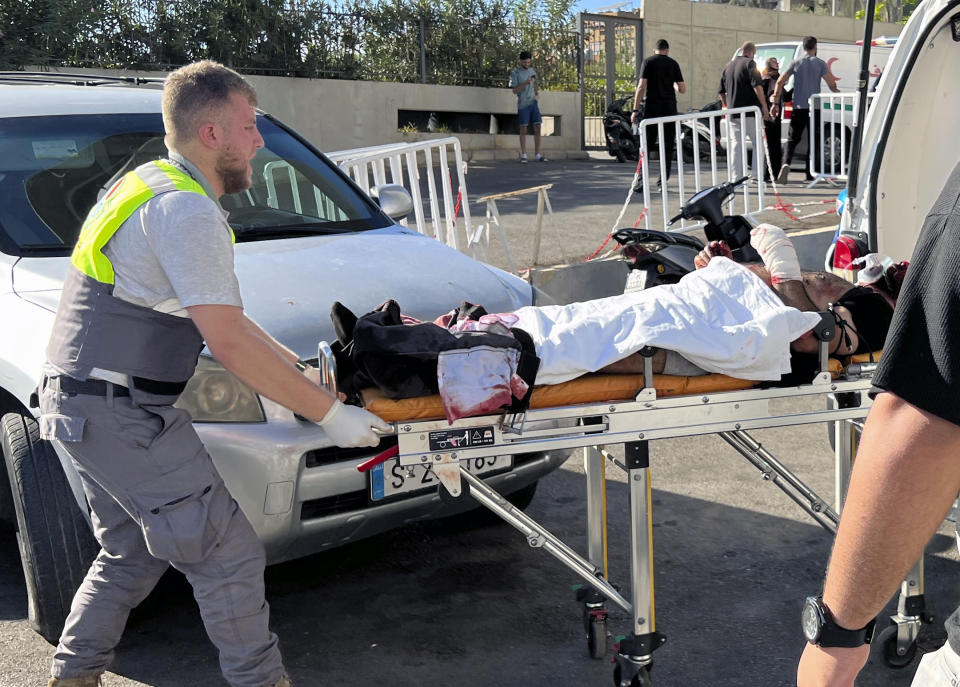 A Civil Defense first-responder carries a wounded man whose handheld pager exploded at al-Zahraa hospital in Beirut, Lebanon, Tuesday, Sept. 17, 2024. (AP Photo/Hussein Malla)