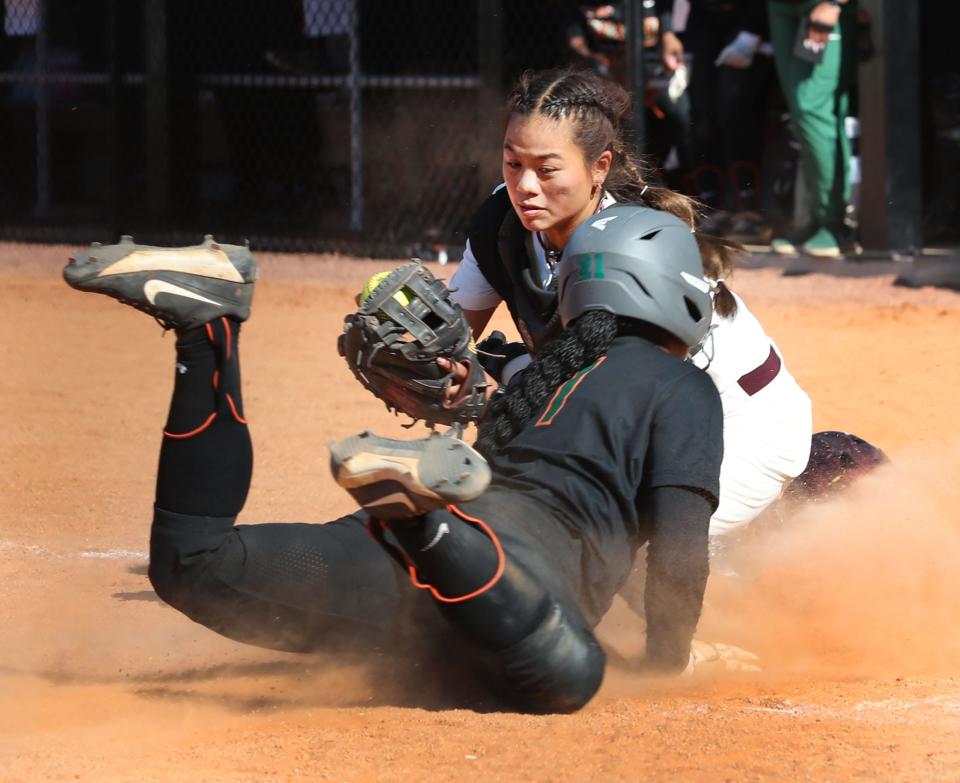 Bethune-Cookman catcher Thais Uyema (11) tags out Florida A&M's Zoryana Hughes (1) at home plate, Friday, March 29, 2024.
