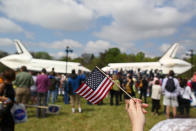 A spectator holds an American flag in front of the Space Shuttle Discovery (R), and the Space Shuttle Enterprise (L), during an event at the Smithsonian National Air and Space Museum Steven F. Udvar-Hazy Center April 19, 2012 in Chantilly, Virginia. The space shuttle Discovery is the he oldest and most traveled vehicle from NASA's space shuttle program, and will replace the Interprise at the museum. (Photo by Mark Wilson/Getty Images)