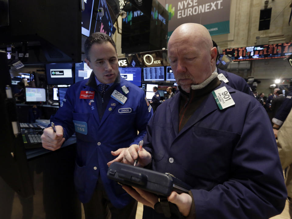 Specialist Jason Hardzewicz, left, and trader John Doyle work on the floor of the New York Stock Exchange Wednesday, Jan. 8, 2014.Stocks are mostly lower in early trading as investors hold back ahead of the release of the latest news from the Federal Reserve. (AP Photo/Richard Drew)