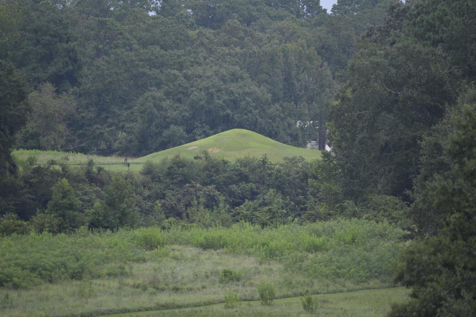 The remains of a funeral mound at the Ocmulgee Mounds National Historical Park in Macon, Ga., on Aug. 22, 2022. The lesser funeral mound remains mostly intact at the Ocmulgee Mounds National Historical Park in Macon, Georgia, on Aug. 22, 2022. A railroad blasted through a much larger burial mound. Archeologists removed millions of artifacts, still held in government archives, and skeletons were put on ghoulish display before the Muscogee managed to rebury 114 ancestors in 2017. (AP Photo/Sharon Johnson)