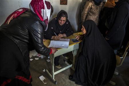 Afghan women wait to receive their voter cards at a voter registration centre in Kabul March 30, 2014. The Afghan presidential elections will be held on April 5. REUTERS/Zohra Bensemra