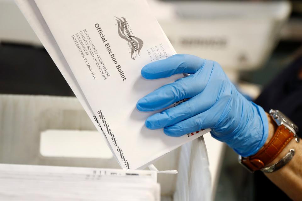 FILE - In this May 27, 2020 file photo, a worker processes mail-in ballots at the Bucks County Board of Elections office prior to the primary election in Doylestown, Pa. The counting from Pennsylvania's first foray into mass voting by mail was wrapping up on Tuesday, June 9 a week after the primary, with results of some of races still up in the air.  (AP Photo/Matt Slocum, File)