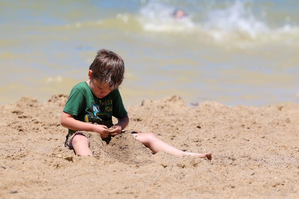 Six-year-old Carson Freet plays in the sand along the lake beach at West Branch State Park.