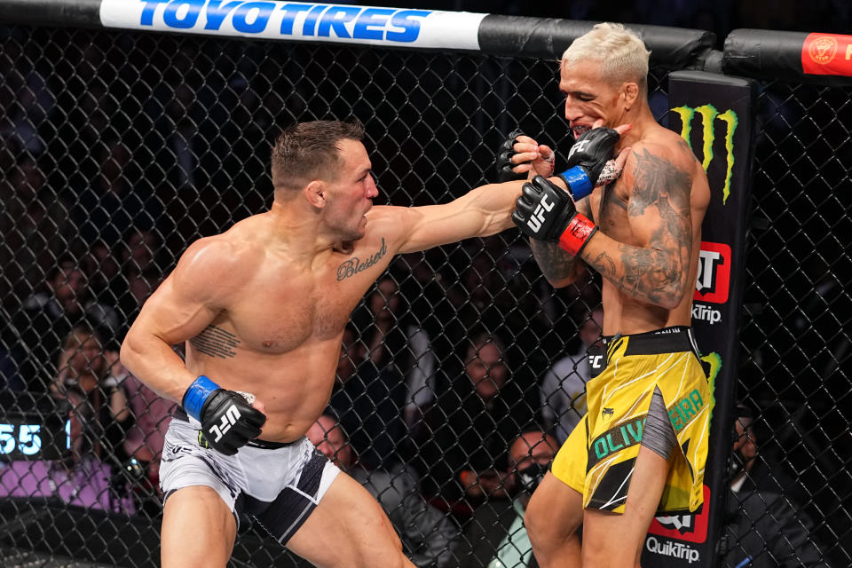 HOUSTON, TEXAS - MAY 15:  (L-R) Michael Chandler punches Charles Oliveira of Brazil in their lightweight championship bout during the UFC 262 event at the Toyota Center on May 15, 2021 in Houston, Texas. (Photo by Josh Hedges/Zuffa LLC via Getty Images)