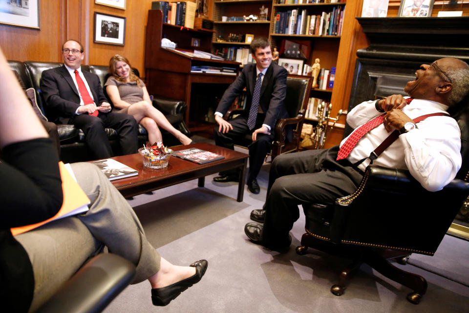 U.S. Supreme Court Justice Clarence Thomas jokes with his clerks as he describes their decision-making process in his chambers.