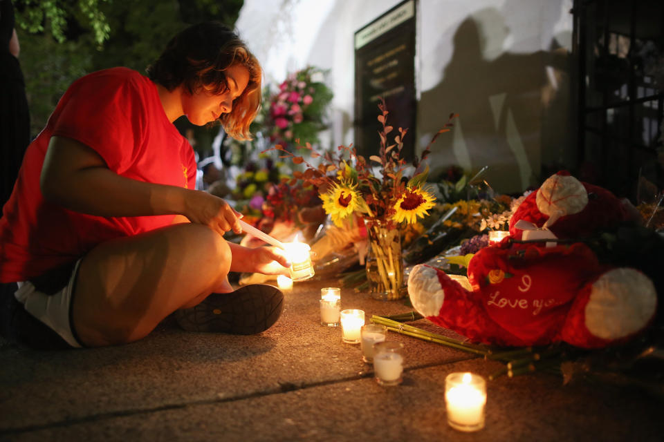 CHARLESTON, SC - JUNE 18:  A woman lights candles for the nine victims of last night's shooting at the historic Emanuel African Methodist Episcopal Church June 18, 2015 in Charleston, South Carolina. Dylann Storm Roof, 21, of Lexington, South Carolina, who allegedly attended a prayer meeting at the church for an hour before opening fire and killing three men and six women, was arrested today. Among the dead is the Rev. Clementa Pinckney, a state senator and a pastor at Emanuel AME, the oldest black congregation in America south of Baltimore, according to the National Park Service.  (Photo by Chip Somodevilla/Getty Images)