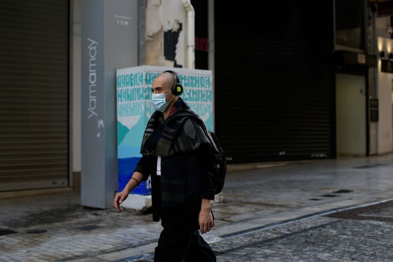 A man wearing a protective face mask makes his way on the main commercial Ermou street, amid the spread of the coronavirus disease (COVID-19), in Athens