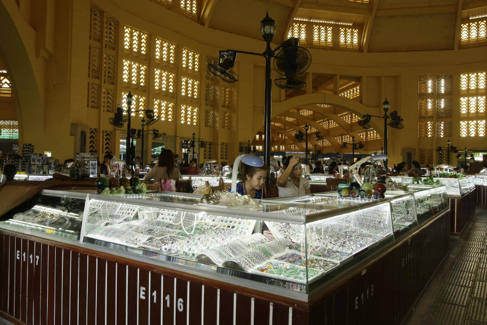 In this Wednesday, Feb. 27, 2013, Cambodian vendors sit in their jewelry booths in the Central Market (Phsar Thum They) in Phnom Penh, Cambodia. Beneath a lemon-yellow art deco dome, the Central Market offers miles of no-strings-attached window-shopping. But if you can't stand the thought of leaving empty-handed, pick up flip-flops, jewelry, delicacies like juicy mangosteen fruit or fried insects, or khama scarves in bright, gingham-like patterns. (AP Photo/Heng Sinith)