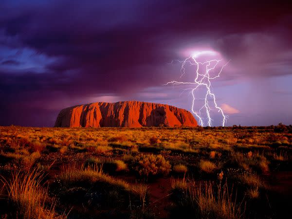 Lightning flashes over Ayers Rock, a landmark red sandstone monolith that draws tourists to Australia's center. Uluru-Kata Tjuta National Park houses the rock, called Uluru by Aborigines, the continent's original inhabitants.