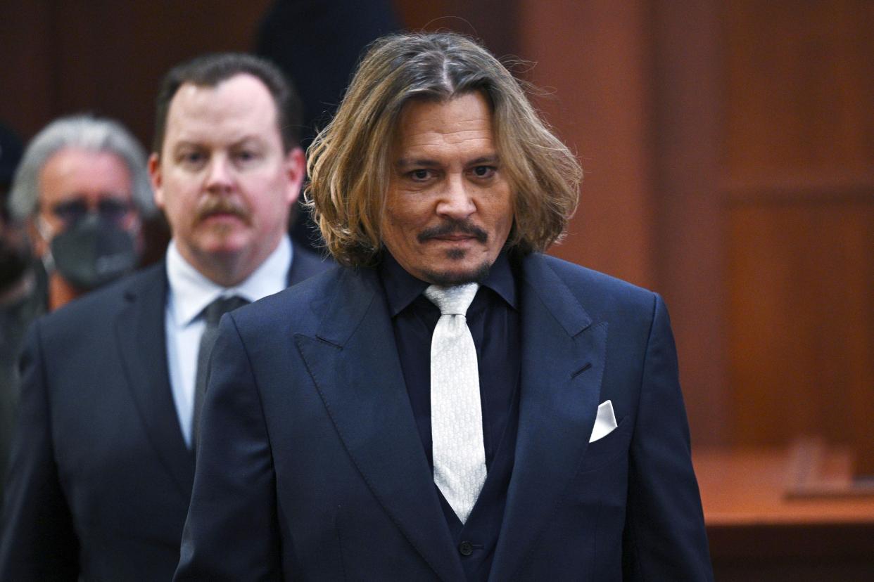 Actor Johnny Depp walks into the courtroom at the Fairfax County Circuit Court April 12, 2022, in Fairfax, Va. A jury in Virginia is scheduled to hear opening statements in a defamation lawsuit filed by Johnny Depp against his ex-wife, Amber Heard. Depp says Heard libeled him when she wrote an op-ed piece in The Washington Post in 2018 referring to herself as a “public figure representing domestic abuse.” Depp is never mentioned by name, but he says the article implicates him nonetheless because it refers to past accusations Heard made when she sought a restraining order against him. A civil j