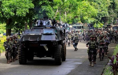 An armoured personnel carrier and government troops march to begin their assault with insurgents from the so-called Maute group, who have taken over large parts of Marawi City, southern Philippines May 25, 2017. REUTERS/Romeo Ranoco